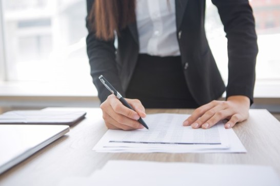 cropped-view-assistant-working-with-document_1262-2107